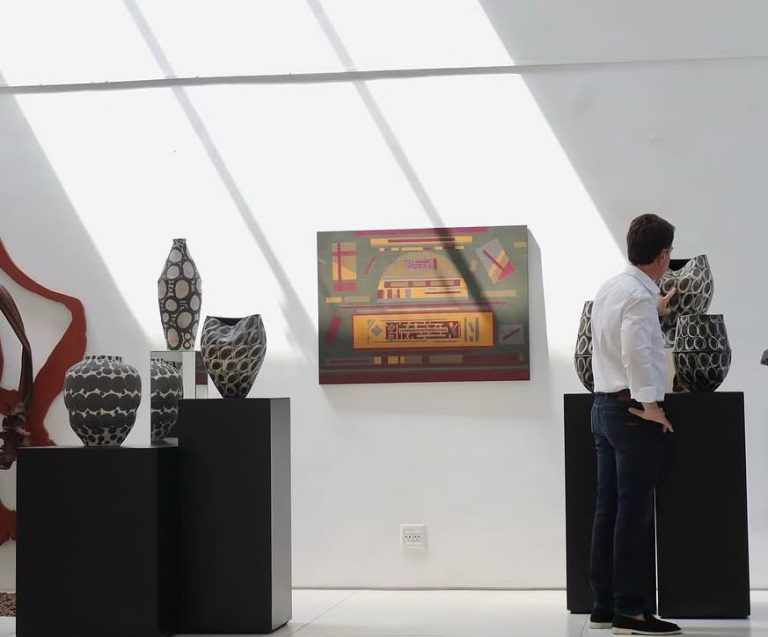 Vista da exposição Afinidades ancestrais na ProArte Galeria, com vasos da coleção Serengeti e obras de arte brasileira