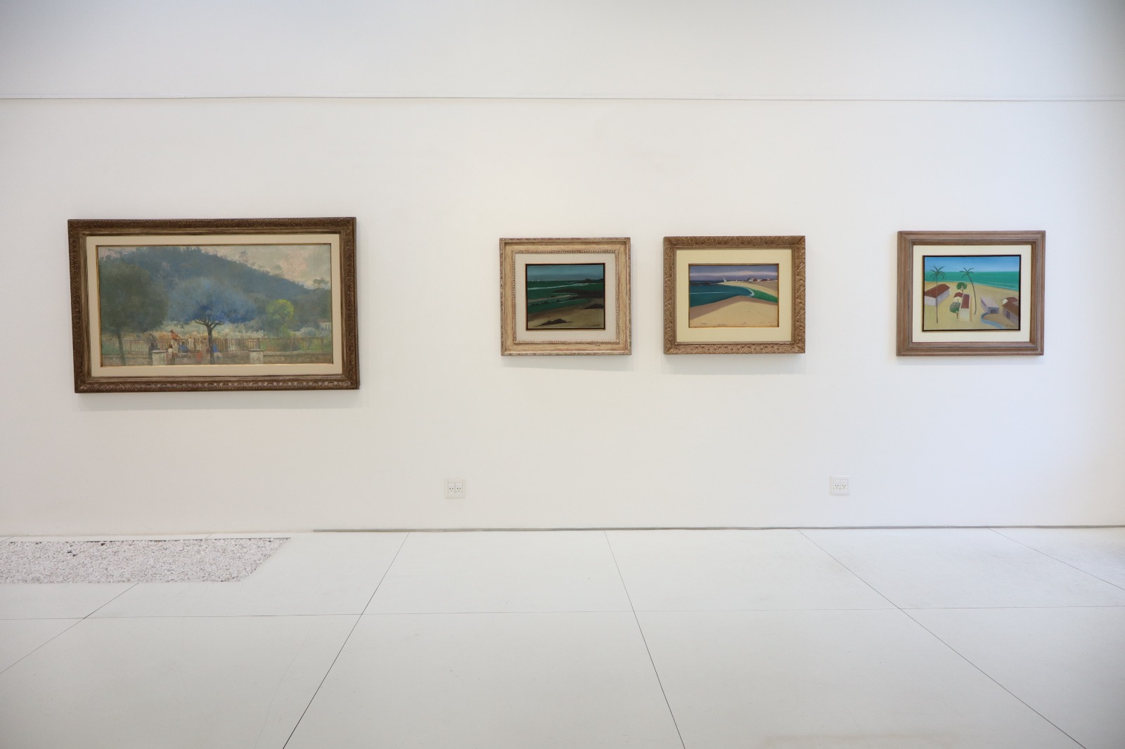 Parede com pinturas de paisagem na exposição Desde um certo ponto